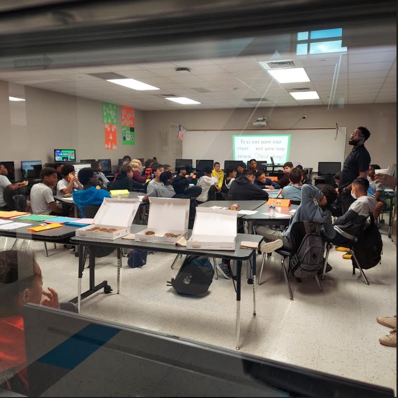 Coach working with a room of middle school students during a session